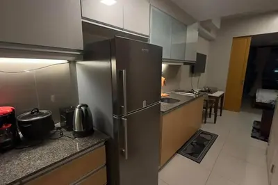 a kitchen with a stainless steel refrigerator and counters at #31 One Uptown Residences BGC in Manila