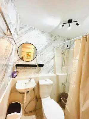 a bathroom with a toilet and a sink and a mirror at #46 Urban Deca Homes Ortigas in Manila