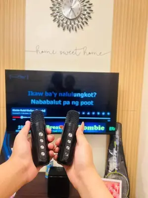 a person holding two remote controls in front of a tv at #46 Urban Deca Homes Ortigas in Manila