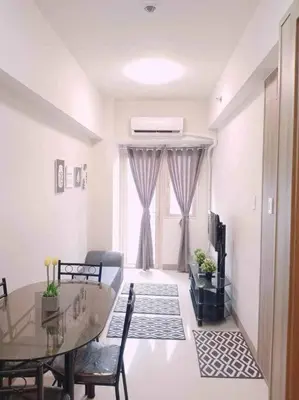 a living room with a glass table and a television at #44 Coast Residences Tower1-20th in Manila