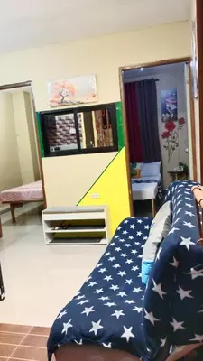 a bedroom with a bed and a tv on a wall at Dencios Transient in Cabuyao