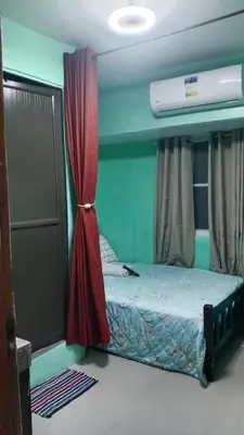 a bedroom with a bed with a red curtain at Dencios Transient in Cabuyao