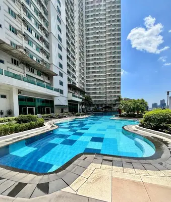 a large swimming pool in the middle of a building at Modern 2BR in Central Makati! Netflix Wi-Fi Pool in Manila