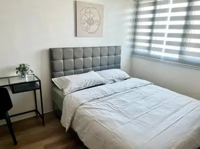 a bedroom with a bed and a table and a window at Modern 2BR in Central Makati! Netflix Wi-Fi Pool in Manila