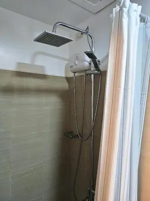 a shower head in a bathroom with a shower curtain at D' Shore Line - Shore Residences MOA PASAY in Manila