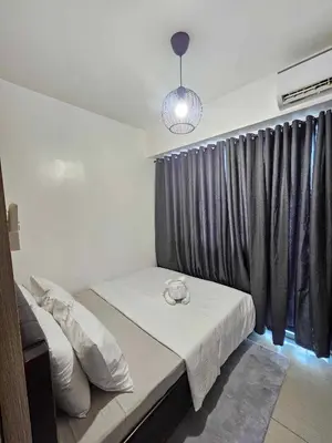 a small bedroom with a bed with a window with at D' Shore Line - Shore Residences MOA PASAY in Manila