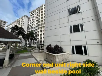 a tall white building with a walk besides pool at Solemare Parksuites Condominium in Manila