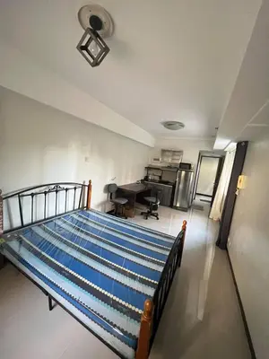 a bedroom with a bed and a desk in a room at Solemare Parksuites Condominium in Manila
