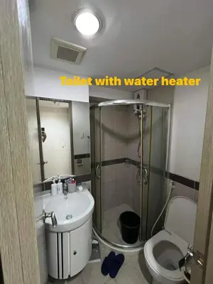 a bathroom with a toilet with a shower and a sink at Solemare Parksuites Condominium in Manila