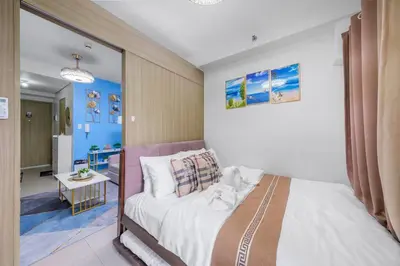 a bedroom with a large bed and a bathroom at 2 Condos, 5 Beds, 2 CR @ Shore2 MOA (3rd&5th Flrs) in Manila