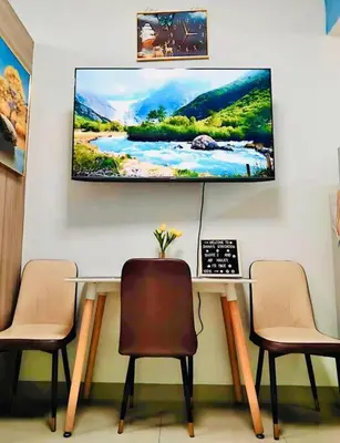 a room with a table with three chairs and a tv on the wall at 2 Condos, 5 Beds, 2 CR @ Shore2 MOA (3rd&5th Flrs) in Manila