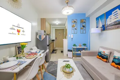 a living room with a couch and a dining room at 2 Condos, 5 Beds, 2 CR @ Shore2 MOA (3rd&5th Flrs) in Manila