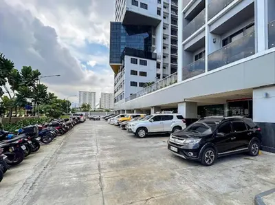 a parking lot with cars parked in front of a building at 2 Condos, 5 Beds, 2 CR @ Shore2 MOA (3rd&5th Flrs) in Manila