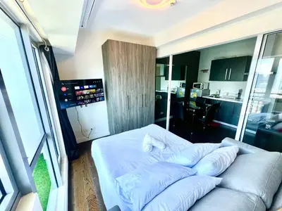 a bedroom with a white bed with pillows on it at Acqua Private Residences - Livingstone Tower (Makati - Mandaluyong) in Manila