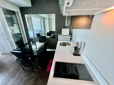 an office with a desk and a kitchen with a sink at Acqua Private Residences - Livingstone Tower (Makati - Mandaluyong) in Manila