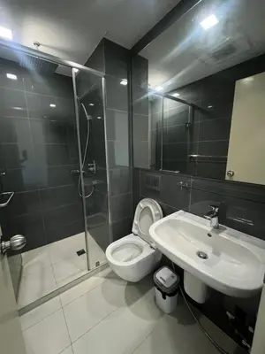 a bathroom with a shower and a toilet and a sink at Acqua Private Residences - Livingstone Tower (Makati - Mandaluyong) in Manila