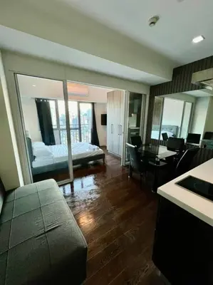 a hotel room with a bed and a table and chairs at Acqua Private Residences - Livingstone Tower (Makati - Mandaluyong) in Manila