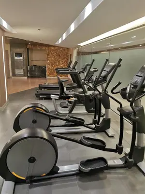 a row of treadmills and ellipticals in a gym at Mall of Asia shore 3 tower 2 condotel in Manila