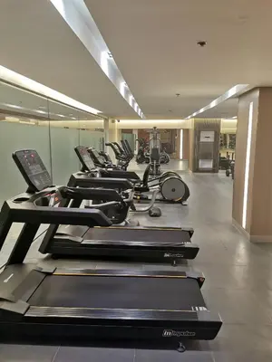 a row of treadmills in a gym with a row at Mall of Asia shore 3 tower 2 condotel in Manila