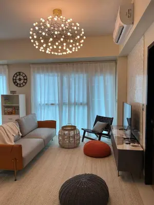 a living room with a couch and a chandelier at Luxurious 1 Br Facing Manila Bay Sunset Nearby Okada MOA Solaire Ayala Malls in Manila