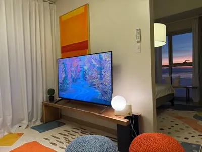 a living room with a flat screen tv on a table at Luxurious 1 Br Facing Manila Bay Sunset Nearby Okada MOA Solaire Ayala Malls in Manila