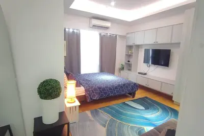 a living room with a bed and a tv at Aveline Suites Luna,1br, Rockwell side in Manila