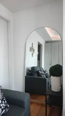 a living room with a couch and a mirror at Aveline Suites Luna,1br, Rockwell side in Manila