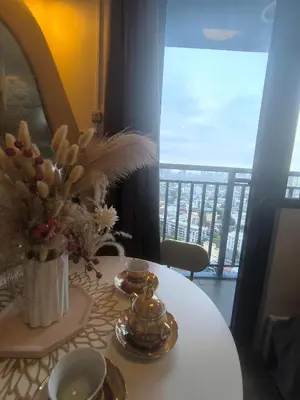 a white table with a vase of flowers on it at Sun and Moon D'wood air residences makati in Manila