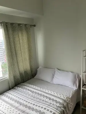 a bed in a room with a window at SEA 2-BR Unit with Free Parking near Mall of Asia in Manila