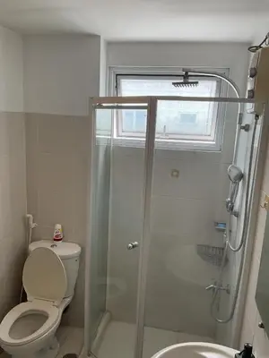 a bathroom with a shower and a toilet and a sink at SEA 2-BR Unit with Free Parking near Mall of Asia in Manila