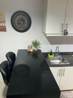 a kitchen with a sink and a clock on the wall at SEA 2-BR Unit with Free Parking near Mall of Asia in Manila