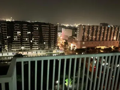 a view of a city at night from a balcony at SEA 2-BR Unit with Free Parking near Mall of Asia in Manila