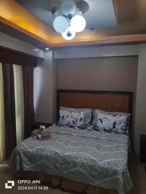a bedroom with a bed with a ceiling fan at Two Palm Tree by Nadz in Manila