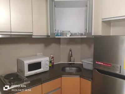 a kitchen with a microwave and a sink at Two Palm Tree by Nadz in Manila
