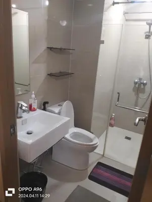 a bathroom with a toilet and a sink and a shower at Two Palm Tree by Nadz in Manila
