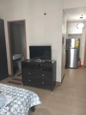 a bedroom with a tv and a dresser with a bed at Two Palm Tree by Nadz in Manila