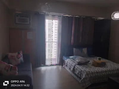 a bedroom with a bed and a couch and a window at Two Palm Tree by Nadz in Manila