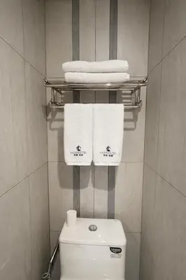 a bathroom with a white toilet and towels at Studio with Balcony Near Okada Manila and MOA LCONDOTEL in Manila