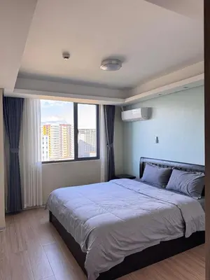 a bedroom with a large bed with a large window at Studio with Balcony Near Okada Manila and MOA LCONDOTEL in Manila