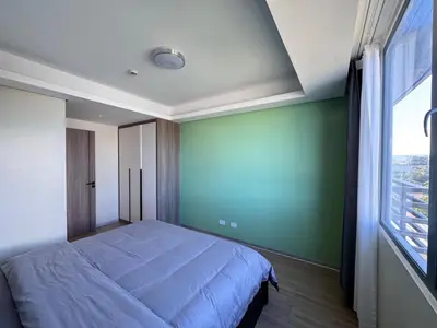 a bedroom with a bed and a green wall at Studio with Balcony Near Okada Manila and MOA LCONDOTEL in Manila