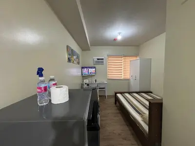 a room with a counter with two bottles of water at Stanford Suites 3, staycation near Nuvali, located in Silang in Bayabasan