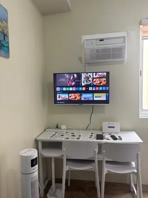 a white table with two chairs and a tv on the wall at Stanford Suites 3, staycation near Nuvali, located in Silang in Bayabasan