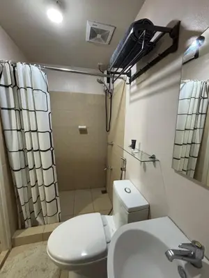 a bathroom with a toilet and a sink and a shower at Stanford Suites 3, staycation near Nuvali, located in Silang in Bayabasan