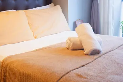 a stuffed animal is sitting on a bed at Condo in Makati with Fast WiFi, Free Pool, Netflix and Own Balcony in Manila