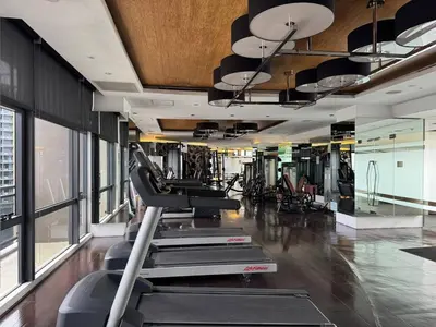 a gym with cardio equipment in a building at Condo in Makati with Fast WiFi, Free Pool, Netflix and Own Balcony in Manila