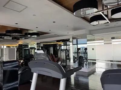 a gym with a row of treadmills in a building at Condo in Makati with Fast WiFi, Free Pool, Netflix and Own Balcony in Manila
