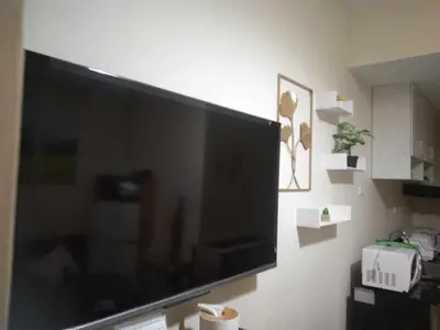 a large flat screen tv hanging on a wall at Mezza II Residences Condotel by Czarynah's Crib in Manila