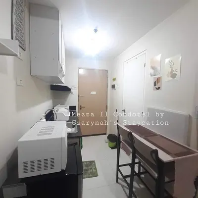 a small kitchen with a table and a microwave at Mezza II Residences Condotel by Czarynah's Crib in Manila
