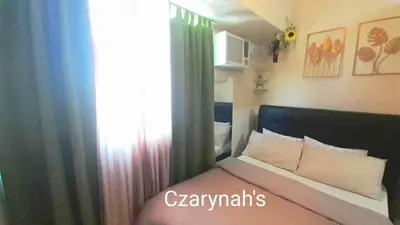 a bedroom with a bed and a window with curtains at Mezza II Residences Condotel by Czarynah's Crib in Manila