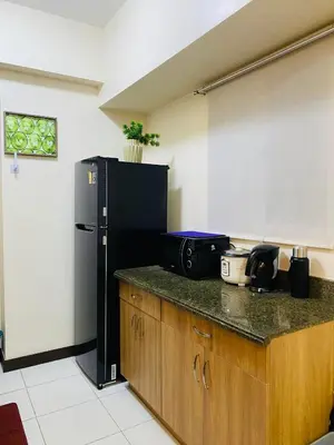 a kitchen with a black refrigerator and a counter at Hello condo in Manila